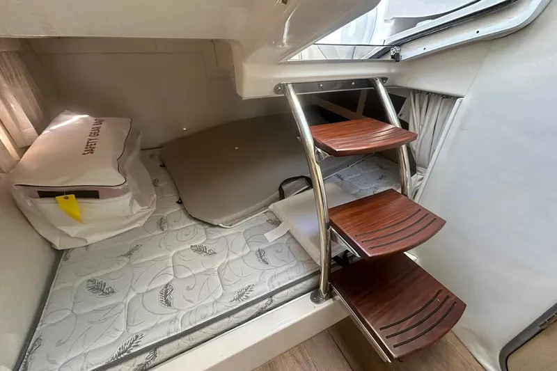 Slide: The Image of 2024 Regal 28 Express cabin interior with wooden steps and mattress. - 43