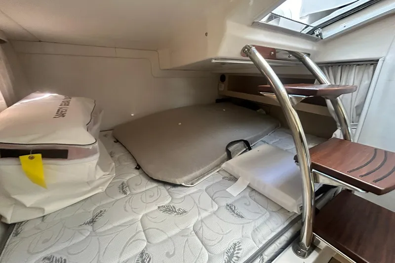 Slide: The Image of 2024 Regal 28 Express cabin interior with mattress, storage, and wooden steps. - 44