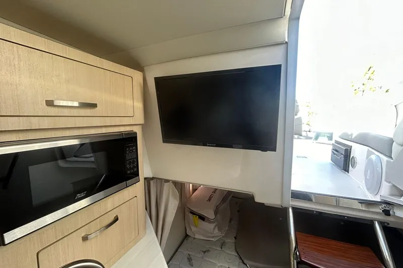 Slide: The Image of 2024 Regal 28 Express interior with TV, microwave, and cabinetry. - 46