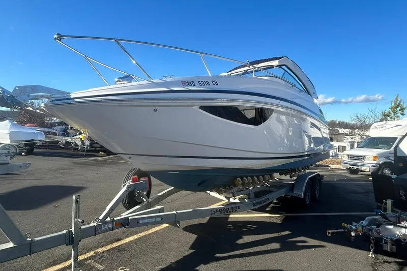 Slide: The Image of 2024 Regal 28 Express boat on trailer in parking lot under clear blue sky. - 8