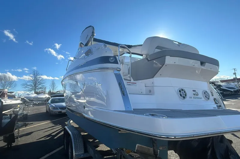 Slide: The Image of 2024 Regal 28 Express boat on trailer under clear blue sky. - 9