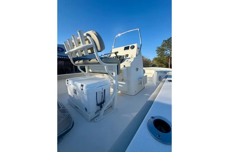 Slide: The Image of 2026 Key West 210 Bay Reef boat interior with seating and cooler, under clear blue sky. - 10