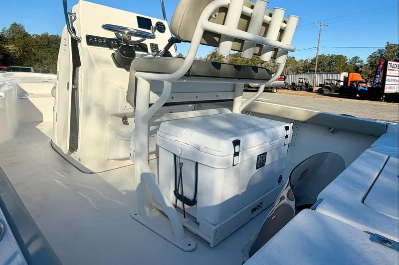 Slide: The Image of 2026 Key West 210 Bay Reef boat interior with console, seating, and cooler. - 12