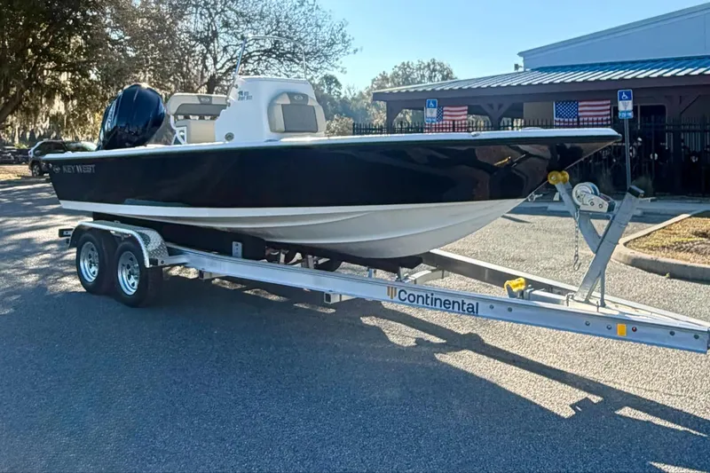 Slide: The Image of 2026 Key West 210 Bay Reef boat on trailer, parked outdoors near building. - 3