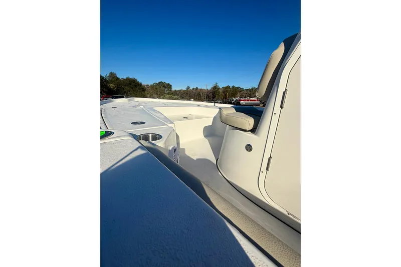 Slide: The Image of 2026 Key West 210 Bay Reef boat interior with seating and cup holders under clear blue sky. - 9