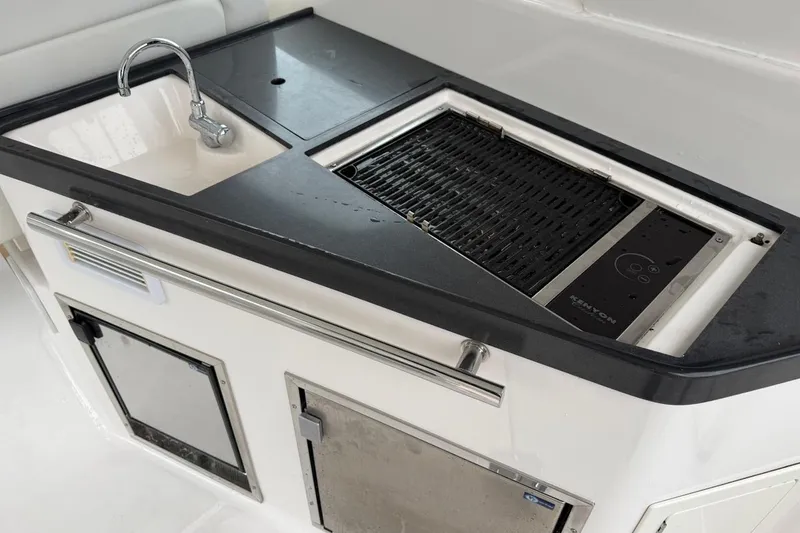 Slide: The Image of Outdoor kitchen area on a 2012 Regal 35 Sport Coupe with sink and grill. - 11