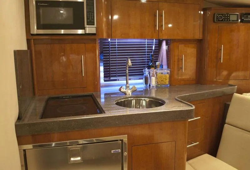 Slide: The Image of Manufacturer Provided Image: 2012 Regal 35 Sport Coupe kitchen with modern appliances and wooden cabinetry. - 15
