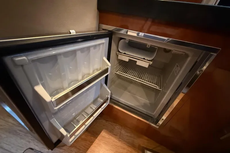 Slide: The Image of Open refrigerator inside 2012 Regal 35 Sport Coupe, showcasing interior storage and shelving. - 19