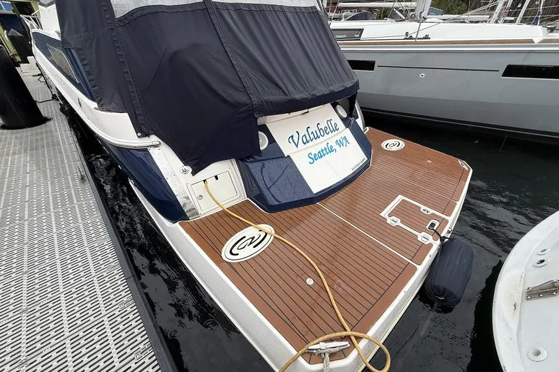 Slide: The Image of 2012 Regal 35 Sport Coupe docked, featuring teak swim platform and covered cockpit. - 33