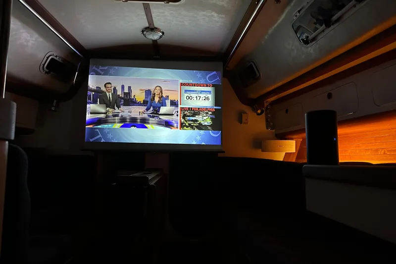 Slide: The Image of Interior of 1992 J Boats J/35 with a TV screen displaying a news broadcast. - 12