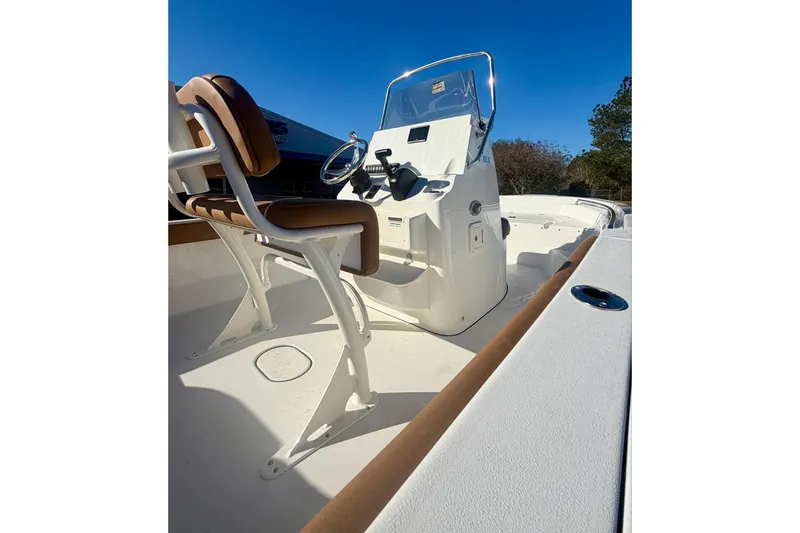 Slide: The Image of 2026 Key West 189 FS boat interior with helm and seating under clear blue sky. - 9