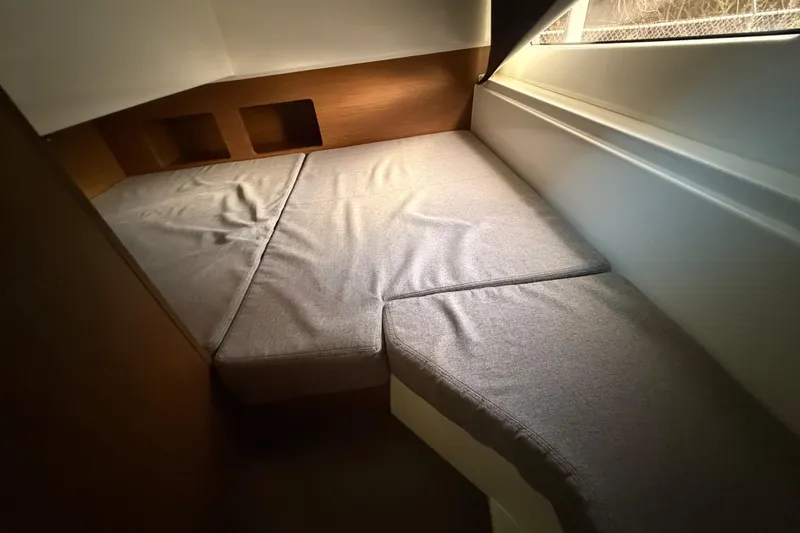 Slide: The Image of Cozy cabin interior of 2019 Beneteau Antares 27 with cushioned seating and wooden accents. - 11