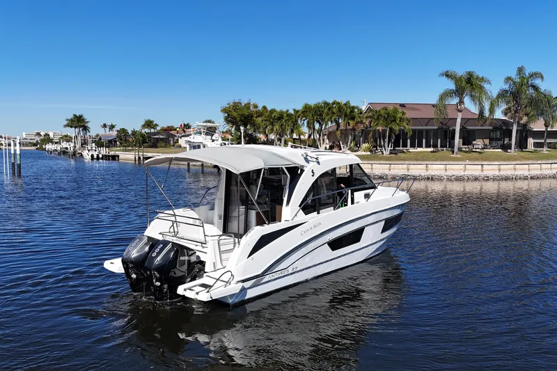 Slide: The Image of 2019 Beneteau Antares 27 boat cruising on a sunny waterfront with palm trees. - 3
