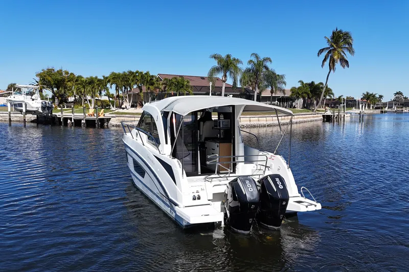 Slide: The Image of 2019 Beneteau Antares 27 boat on calm water with palm trees in the background. - 4