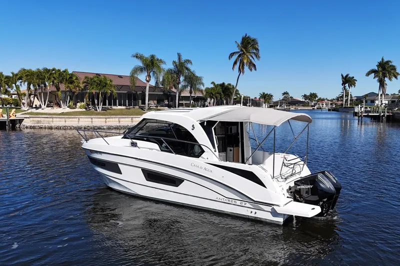 Slide: The Image of 2019 Beneteau Antares 27 boat cruising on a sunny day with palm trees in the background. - 5