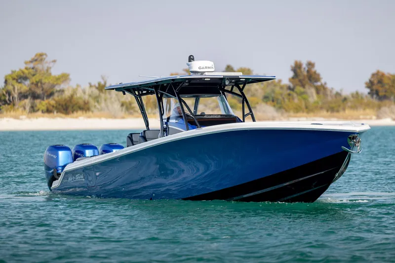 Slide: The Image of 2020 Nor-Tech 390 Sport Center Console boat on water, featuring sleek blue design. - 10