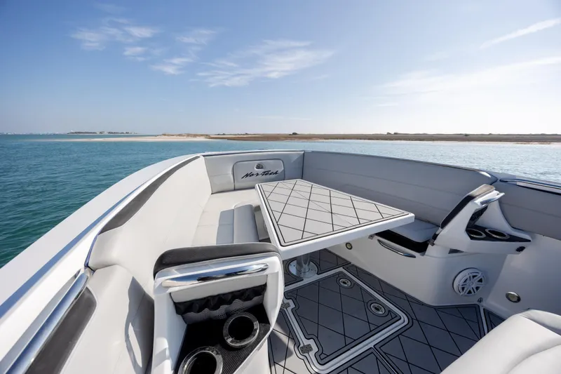 Slide: The Image of 2020 Nor-Tech 390 Sport Center Console boat interior with seating and table on open water. - 14