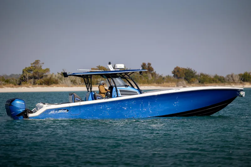 Slide: The Image of 2020 Nor-Tech 390 Sport Center Console boat cruising on water, side view. - 2