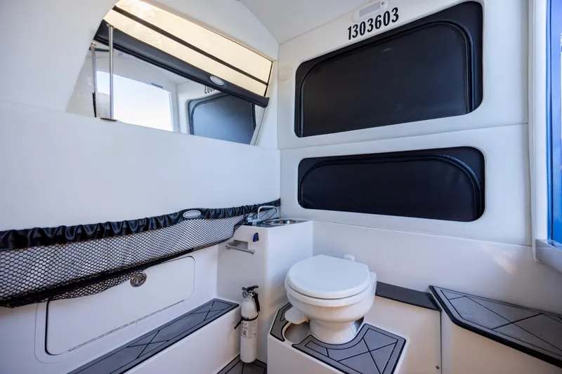 Slide: The Image of 2020 Nor-Tech 390 Sport Center Console boat interior with toilet and storage. - 21