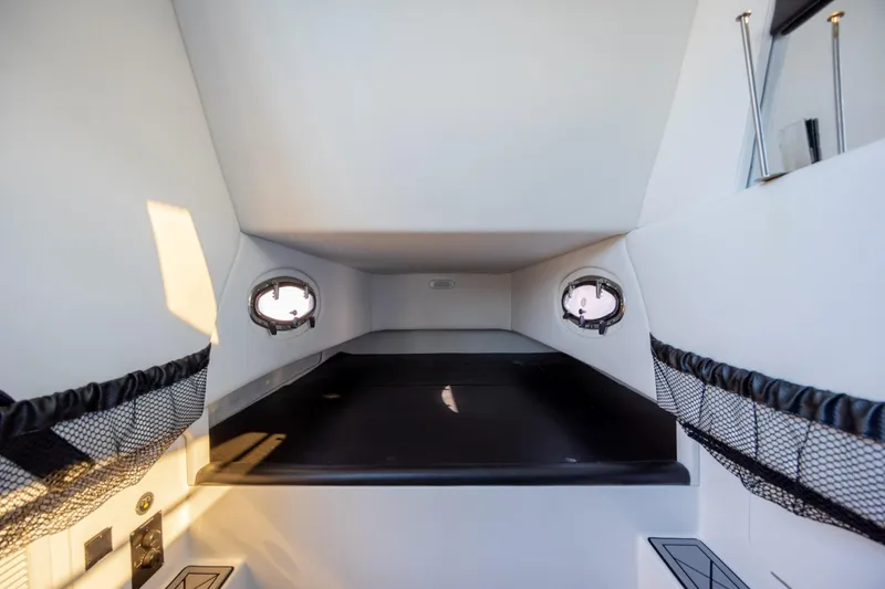 Slide: The Image of 2020 Nor-Tech 390 Sport Center Console cabin interior with portholes and storage nets. - 23