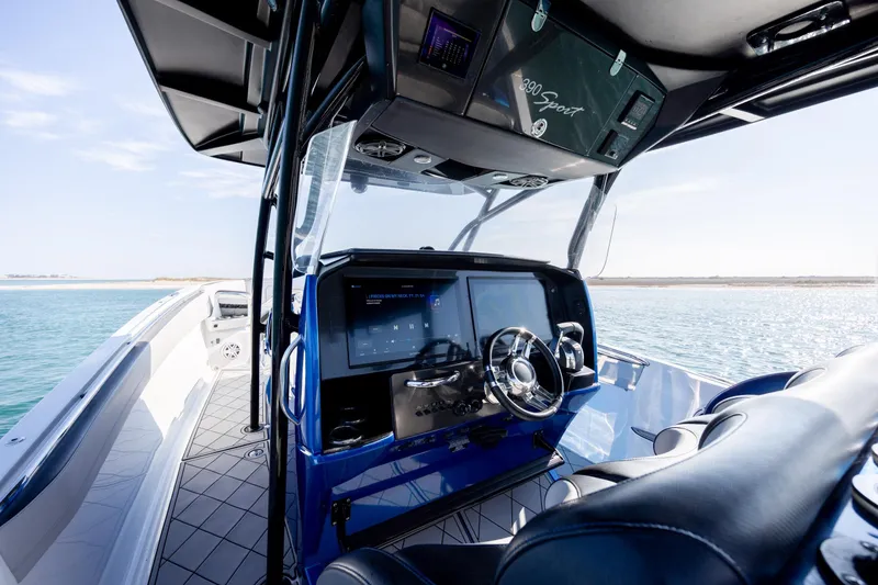 Slide: The Image of 2020 Nor-Tech 390 Sport Center Console boat interior with modern dashboard and steering wheel. - 26