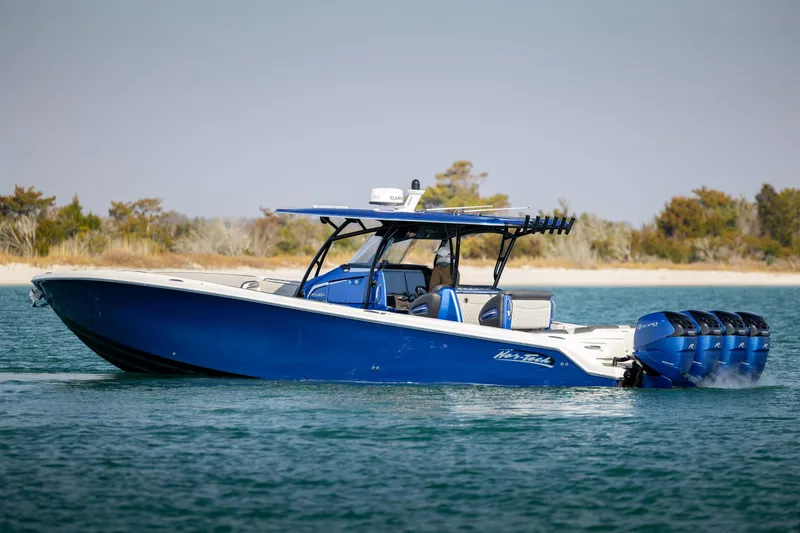 Slide: The Image of 2020 Nor-Tech 390 Sport Center Console boat cruising on water, featuring sleek blue design. - 6