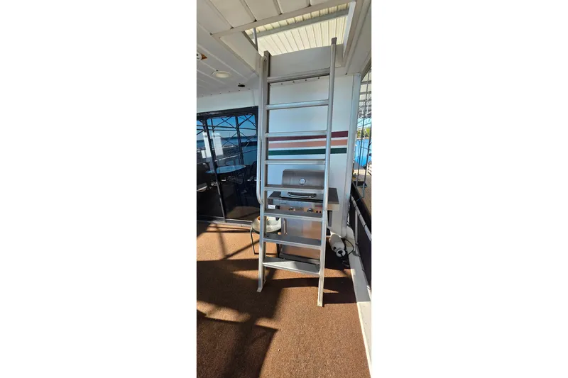 Slide: The Image of 1999 Stardust Cruisers 16x60 houseboat with ladder and outdoor grill on deck. - 11