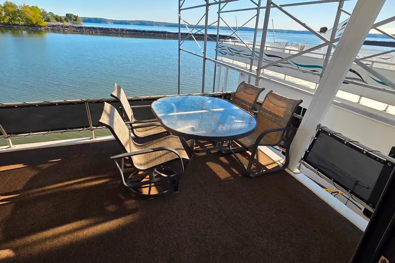 Slide: The Image of Outdoor seating on 1999 Stardust Cruisers 16x60 houseboat, overlooking serene lake view. - 14