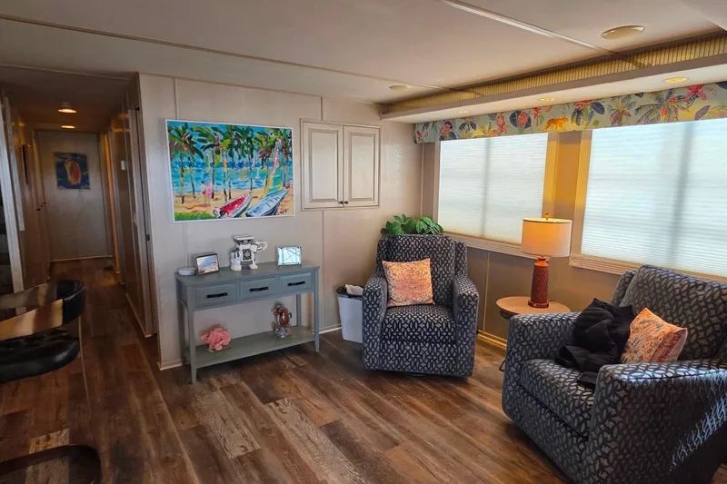Slide: The Image of Cozy living area in 1999 Stardust Cruisers 16x60 houseboat with tropical decor and comfortable seating. - 29