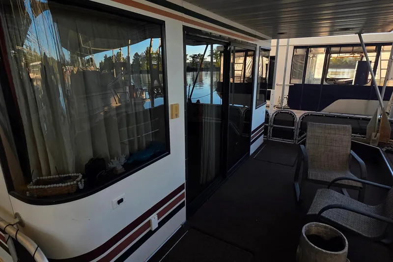 Slide: The Image of 1999 Stardust Cruisers 16x60 houseboat deck with chairs and waterfront view. - 3