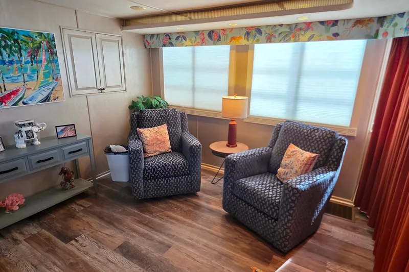 Slide: The Image of Cozy living area in a 1999 Stardust Cruisers 16x60 houseboat with armchairs and decor. - 33