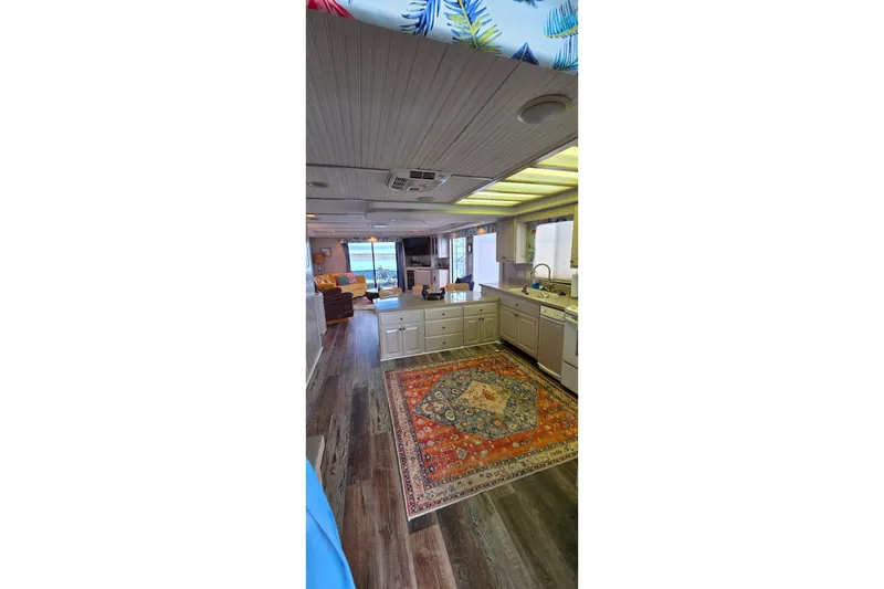 Slide: The Image of Interior of 1999 Stardust Cruisers 16x60 houseboat with kitchen and vibrant rug. - 42