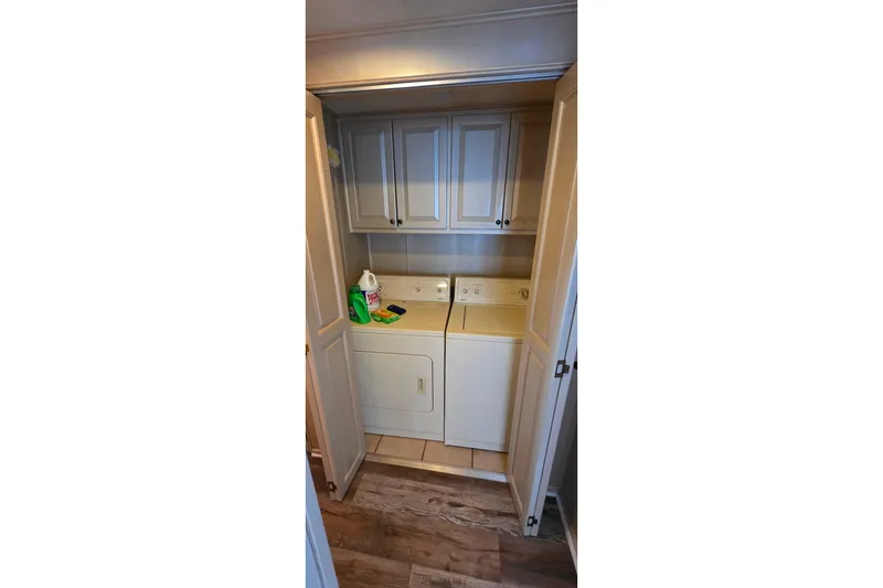 Slide: The Image of Laundry area in 1999 Stardust Cruisers 16x60 houseboat with washer, dryer, and storage cabinets. - 46