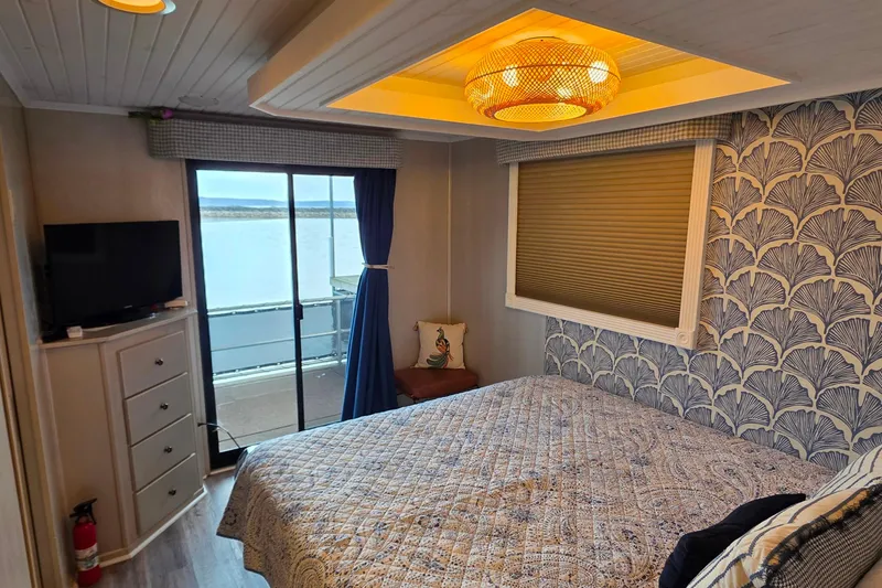 Slide: The Image of Cozy bedroom in 1999 Stardust Cruisers houseboat with lake view and elegant decor. - 62