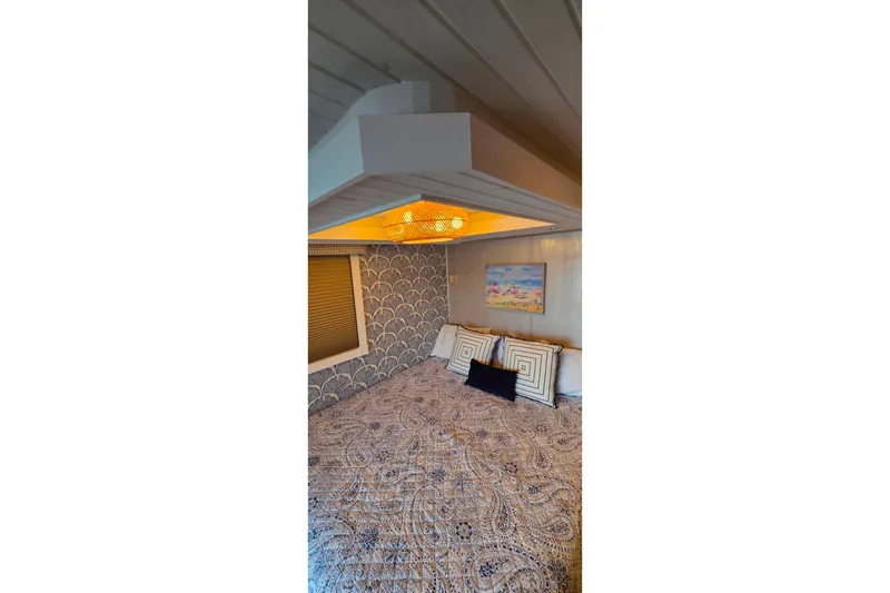 Slide: The Image of Cozy bedroom in 1999 Stardust Cruisers 16x60 houseboat with patterned bedding and wall art. - 63