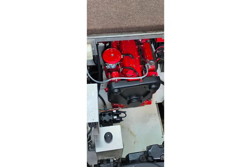 Slide: The Image of Engine compartment of a 1999 Stardust Cruisers 16x60 houseboat, featuring a red engine. - 74