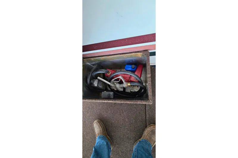 Slide: The Image of Storage compartment on 1999 Stardust Cruisers 16x60 houseboat, containing hoses and equipment. - 76