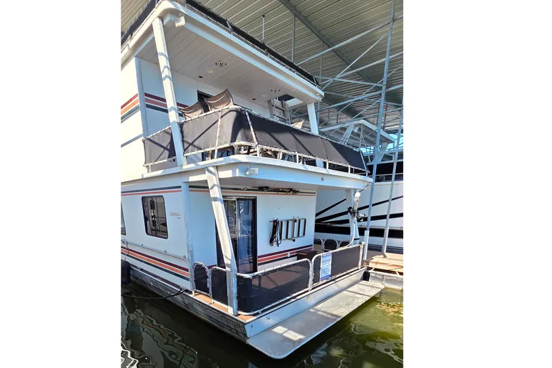 Slide: The Image of 1999 Stardust Cruisers 16x60 houseboat docked, featuring upper deck and water reflection. - 8