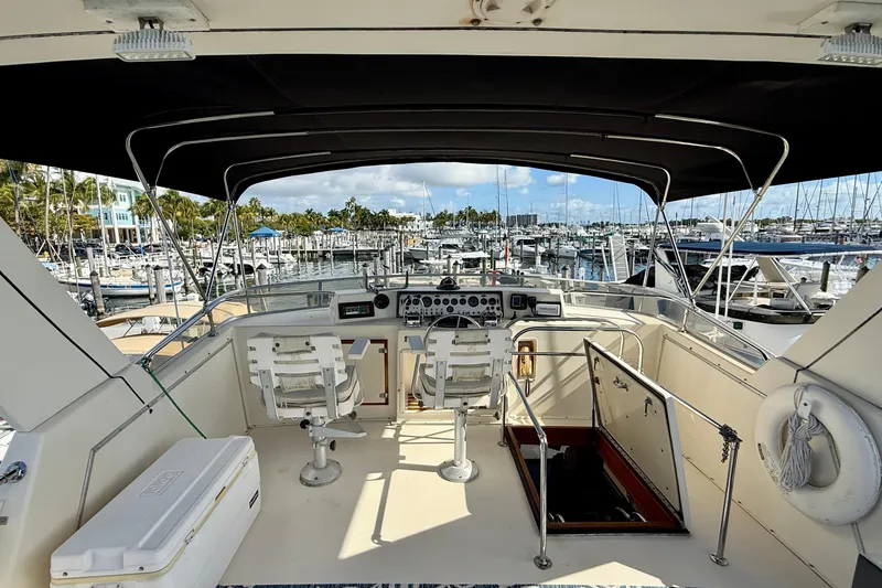 Slide: The Image of 1987 Chris-Craft 500 Constellation yacht helm with marina view, featuring dual captain chairs. - 24