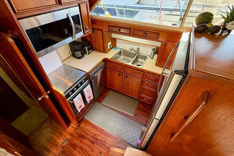 Slide: The Image of 1987 Chris-Craft 500 Constellation yacht kitchen with wood cabinetry and modern appliances. - 7