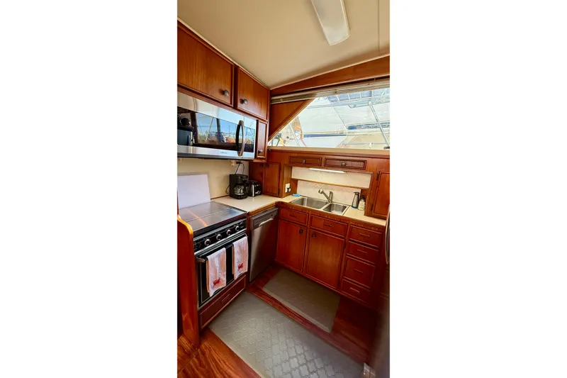 Slide: The Image of 1987 Chris-Craft 500 Constellation yacht kitchen with wood cabinetry and modern appliances. - 8