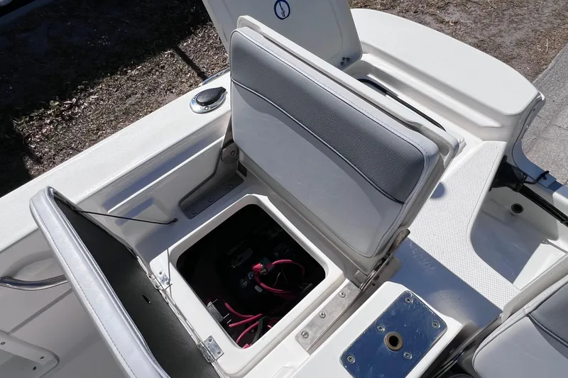 Slide: The Image of 2021 NauticStar 227 XTS boat seat storage compartment with battery visible. - 25