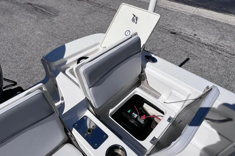 Slide: The Image of 2021 NauticStar 227 XTS boat with open storage compartments and visible battery. - 26