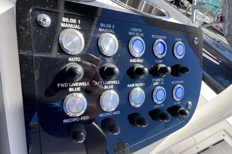 Slide: The Image of Control panel of 2021 NauticStar 227 XTS boat with various switches and buttons. - 34