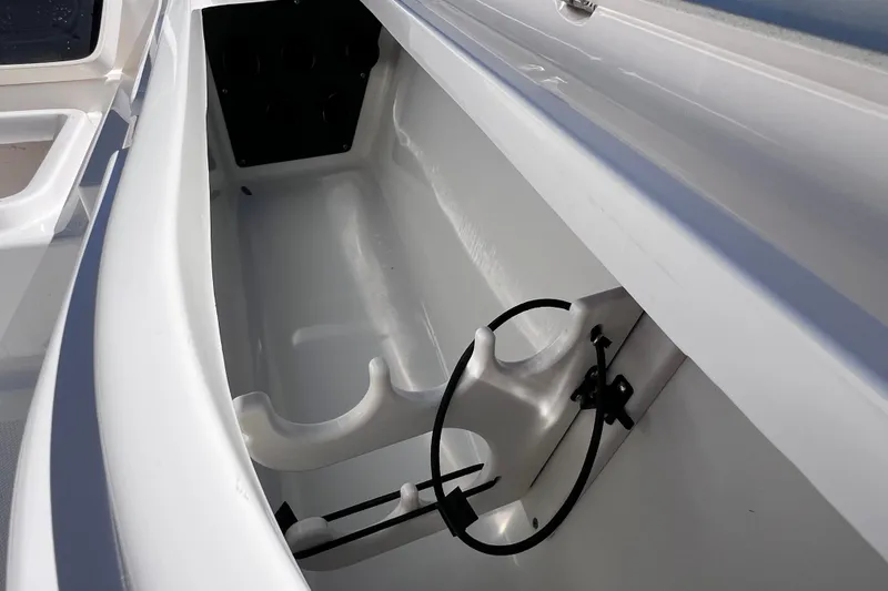 Slide: The Image of 2021 NauticStar 227 XTS boat storage compartment with rod holders. - 46
