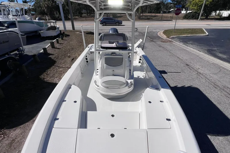 Slide: The Image of 2021 NauticStar 227 XTS boat, white interior, parked on a street near other boats. - 48
