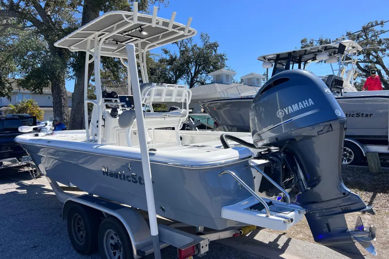Slide: The Image of 2021 NauticStar 227 XTS boat with Yamaha engine on trailer, parked outdoors. - 6