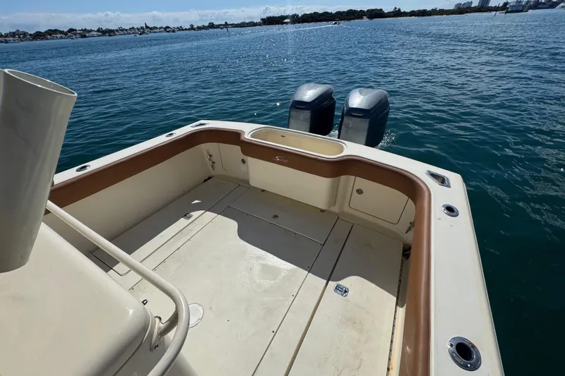 Slide: The Image of 2004 Scout 280 Sportfish boat deck with twin outboard motors on calm water. - 15