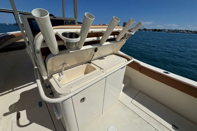 Slide: The Image of 2004 Scout 280 Sportfish boat with rod holders and sink, docked by the water. - 16