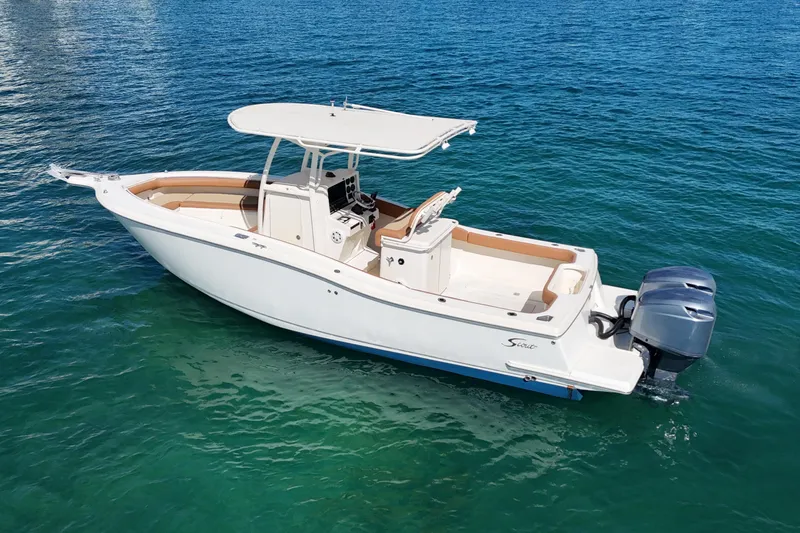 Slide: The Image of 2004 Scout 280 Sportfish boat on clear blue water, featuring twin outboard engines. - 2